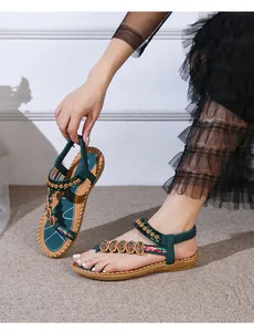 Detail of bohemian dark green flat sandals featuring heart ornaments and floral embroidery