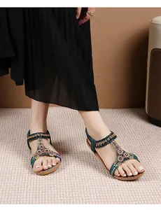 Detail van groene boho sandalen met kleurrijke kralen en metalen bloemaccenten