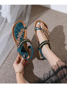 Detail of bohemian flat sandal featuring turquoise beads and sunflower embroidery