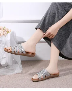 Detail of silver sequin braided straps on stylish flat summer mule sandals