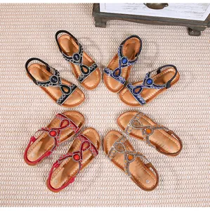 Détails des sandales plates bohèmes avec perles et strass en plusieurs couleurs sur tapis