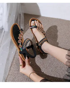Close-up of bohemian flat sandals with heart floral accents and ethnic braided straps