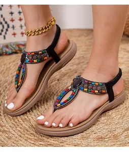 Close-up of Bohemian sandals with colorful beads and rhinestones on a flat T-strap