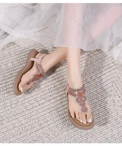 Detail of bohemian flat sandals with ethnic beads and embroidery on T-strap