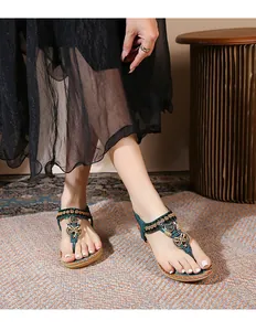 Detail of bohemian flat sandals with teal T-strap and vintage bead heart charms