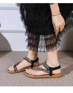 Detail of bohemian flat sandals with ethnic embroidery and heart-shaped beads