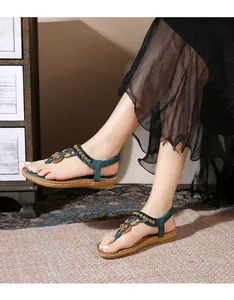 Detail of bohemian teal flat sandals with colorful beads and vintage floral embellishments