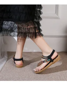 Close-up of Bohemian sandals with ethnic heart beads and embroidery details on a model