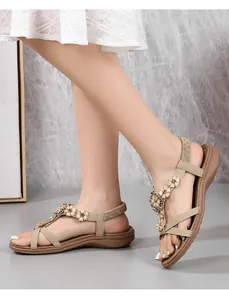 Détail de sandales bohèmes avec broderie perlée florale et fines brides kaki
