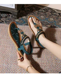 Close-up of bohemian flat sandals with beaded floral decor and woven details