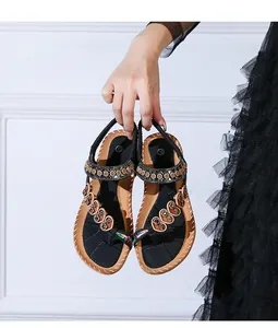 Detail of bohemian flat sandals featuring rhinestone heart accents and contrast stitching