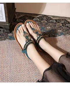 Detail of Bohemian flat sandals featuring intricate embroidery and emerald green beadwork
