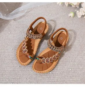 Detail of brown Bohemian sandals with sequin straps and heart cutout pattern