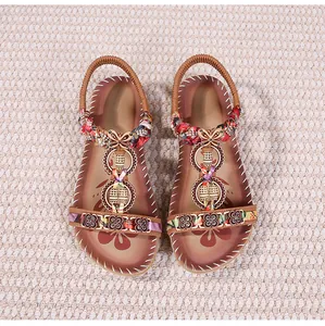 Vista dettagliata di sandali boho con cinturini floreali e ornamenti in metallo etnico