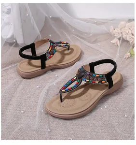 Detail of bohemian flat sandals with colorful beads, rhinestones, and elastic heel strap