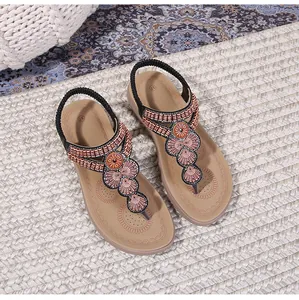 Detail view of Bohemian thong sandals with intricate geometric beadwork and elastic strap