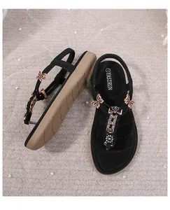 Sandalias planas con pedrería, dije de mariposa en oro rosa y correa elástica al talón