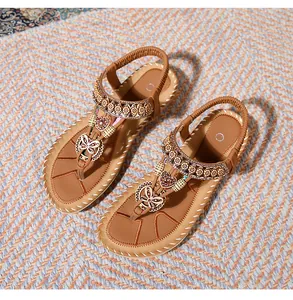 Detail of bohemian flat sandals with intricate beads, metal butterfly and heart charms