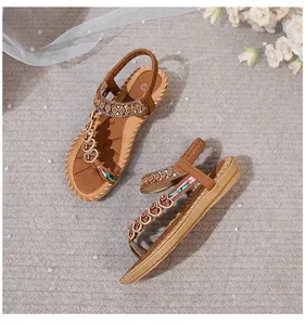 Detail of bohemian flat sandals with heart buckle, floral webbing, and woven stitching
