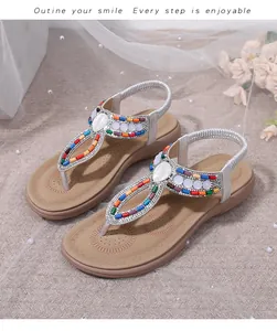 Detailed view of bohemian flat sandals featuring colorful beads and pearl decorations