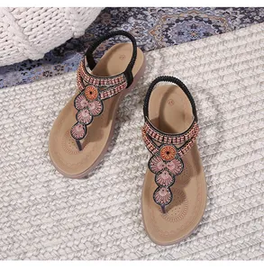 Detail of bohemian thong sandals featuring intricate copper and rose gold floral beadwork