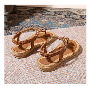 Detail of bohemian flat sandals featuring yellow beads and brown elastic back strap