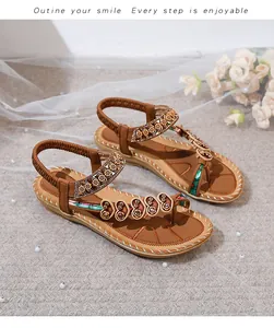 Detail of Bohemian flat sandals with floral metal charms and elastic heel strap