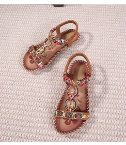 Dettaglio dei sandali boho con stampe colorate e ornamenti floreali in metallo etnico