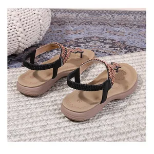 Detail of flat flip-flop sandals with beaded bow and elastic back strap on a 37 size footbed