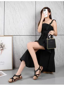 Détail de sandales noires à strass portées par un mannequin dans un style urbain d'été