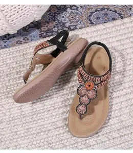 Macro detail of bohemian flat sandals with sparkling rhinestones and elastic heel strap