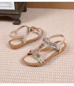 Detail van bohemien sandalen met sprankelende strassbloemen en etnische bandjes