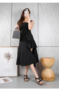 Sandales bohèmes avec perles portées avec une robe noire à volants asymétrique