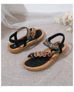 Detailed view of bohemian flip-flop sandals featuring heart-shaped beads and rhinestones