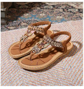 Detail of bohemian flat sandals with vintage butterfly beads and elastic ankle strap