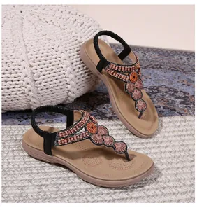 Close-up of bohemian thong sandals with colorful beads and rhinestone floral details