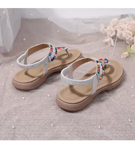 Detail of flat flip-flop sandal with colorful beads and elastic silver heel strap