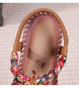Dettagli dei cinturini in seta floreale con strass e cinturino elastico sul tallone dei sandali