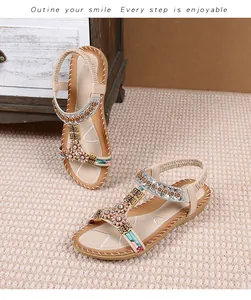 Detailopname van bohemien platte sandalen met strass zonnebloem en kralendecoraties