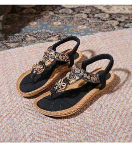 Detail of bohemian flat sandals with wooden butterfly accents and floral beadwork