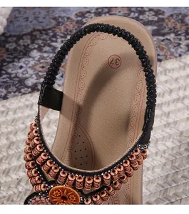 Detail of bohemian flat sandals featuring ethnic beadwork and a circular floral motif