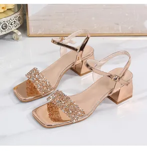Macro detail of rose gold block heel sandal featuring shimmering rhinestone straps