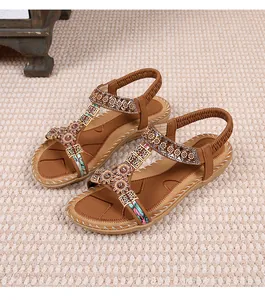 Detailopname van bruine bohemian sandalen met verfijnde bloemmotieven van kralenwerk
