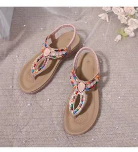 Detail of bohemian flat sandals with colorful beadwork and elastic heel straps
