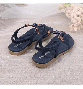 Detalle de sandalias de dedo azul marino con mariposa de cristal y cuentas decorativas
