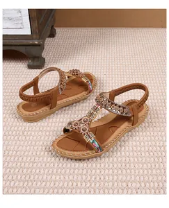 Detail van boheemse platte sandalen met bloemenpatches en vintage kralenborduursel