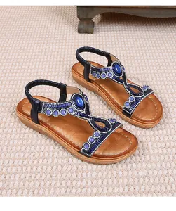 Détail de sandales plates bohèmes avec perles bleues, cristaux et bride élastique