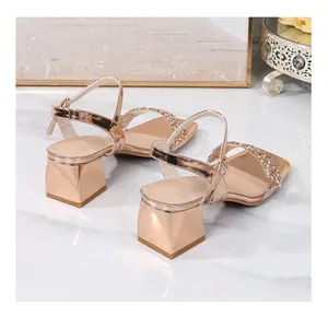Detail view of gold block heel sandal featuring rhinestone straps and ankle buckle