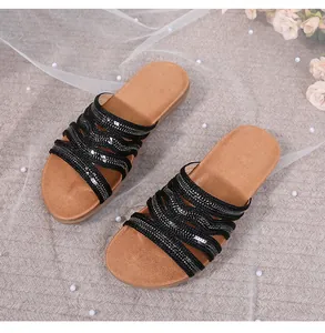 Detail of bohemian flat sandals with sparkling black sequin straps and comfy footbed