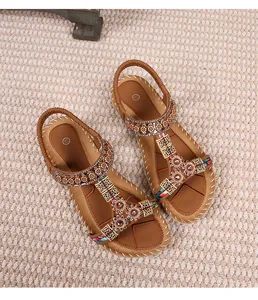 Detail van bohemien platte sandalen met vintage metalen bloemen en kleurrijke kralen